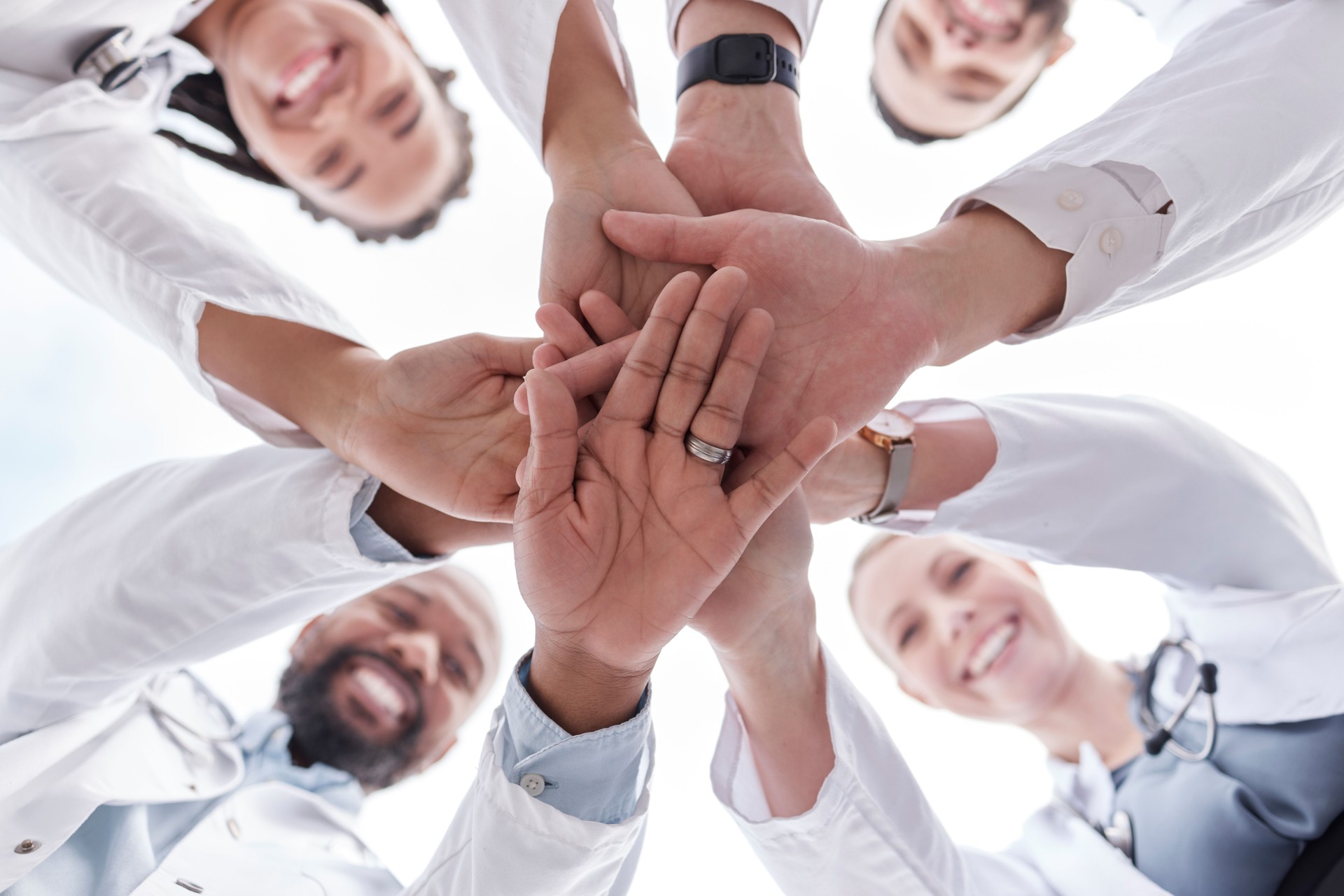 Hospital doctors, happy people and circle hands together for healthcare teamwork, medical team building and clinic celebration. Solidarity, below view and group surgeon for collaboration success